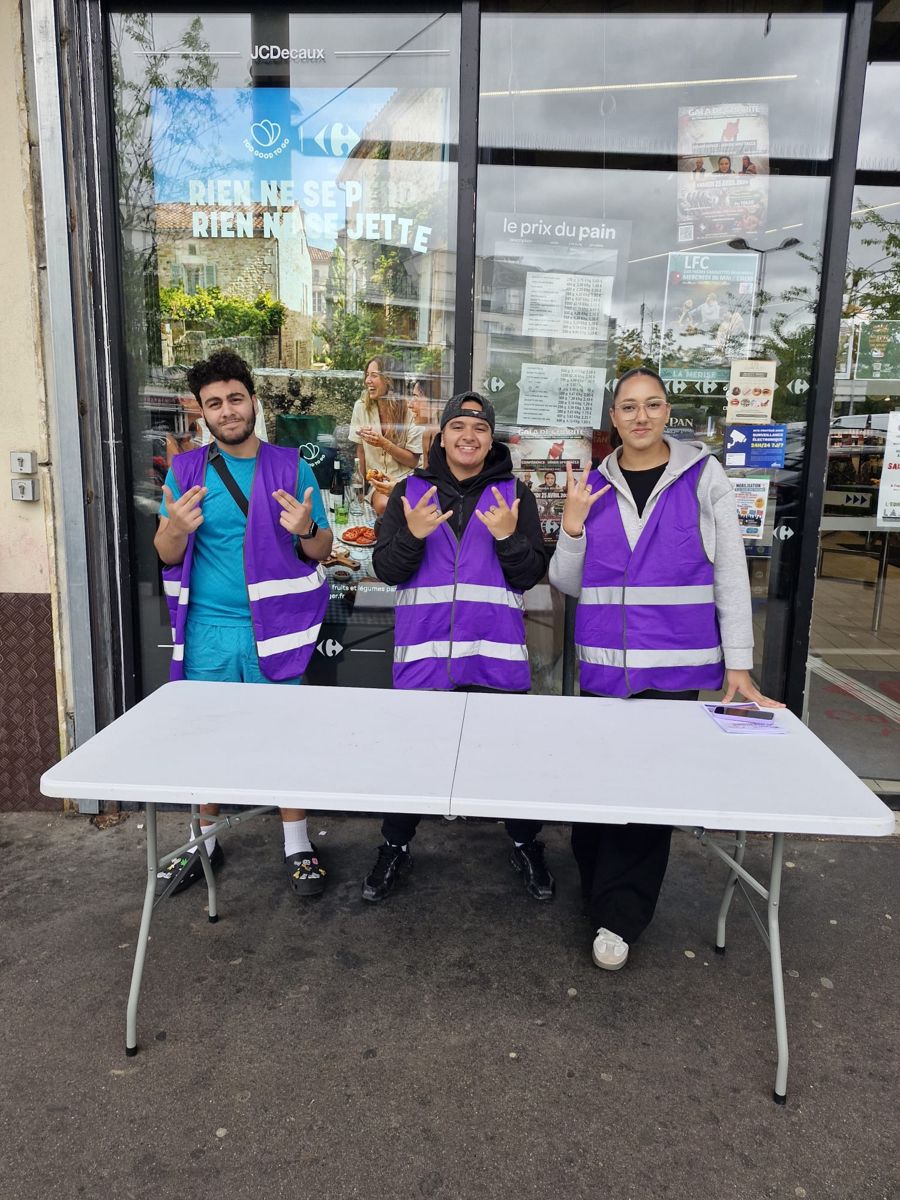 Bénévoles de Nour en gilet violet sur leur stand de collecte